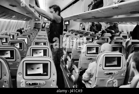 Passengers embarking and settling into a plane flight Stock Photo