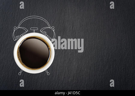 Coffee break concept. Coffe cup and sketch of alarm clock on black slate background. Stock Photo