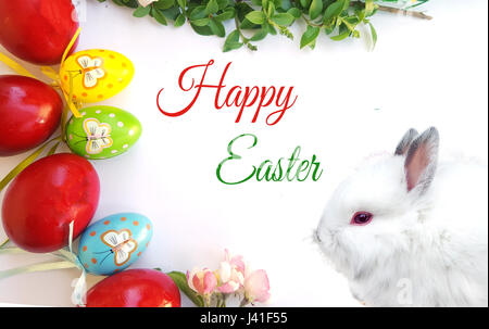 Easter composition with green tree branch, white bunny and easter eggs Stock Photo