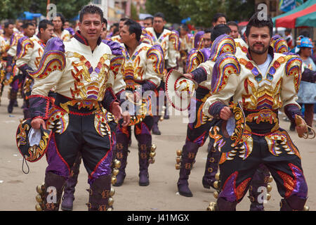 Caporales dancers in ornate costumes performing as they parade through the mining city of Oruro on the Altiplano of Bolivia during the annual carnival Stock Photo