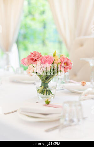 Flower table decorations for holidays and wedding dinner. Table set for holiday, event, party or wedding reception in outdoor restaurant. Stock Photo