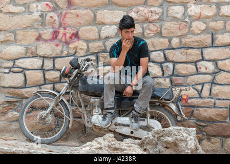 Young Man Sitting On His Motorcycle, Esfidan, A Traditional Rural Village, North Khorasan Province, IRAN Stock Photo