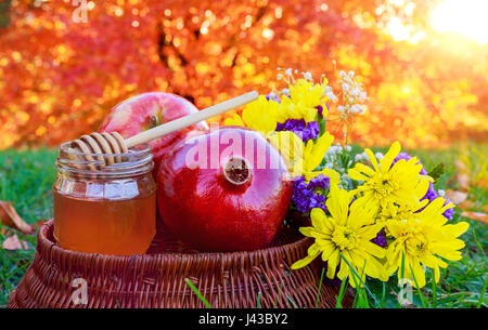 Honey, apple and pomegranate on wooden table over bokeh background Stock Photo
