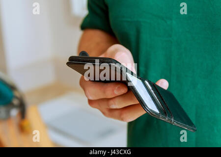 business, technology, navigation and people concept - close up of male hand holding and showing smart phone and watch at train station with the Train  Stock Photo