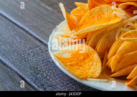 Bowl of potato chips in a black wooden background Stock Photo