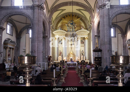 People praying inside the Metropolitan Tabernacle (Spanish: Sagrario Metropolitana) located at the Plaza de la Constitucion or Zocalo in Downtown Mexico City capital of Mexico Stock Photo