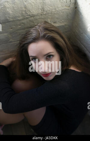High angle view portrait of a serious young woman sitting down staring Stock Photo
