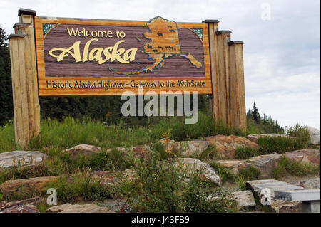 Roadsign welcoming travelers to Alaska at border to Yukon Terr. Canada, USA Stock Photo