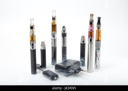 Thin e-cigarettes with charger and smoke on white background Stock ...