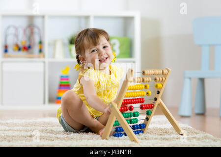 smiling kid girl playing with counter toy Stock Photo