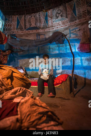 Ethiopian boy inside his traditional painted and decorated house, Kembata, Alaba Kuito, Ethiopia Stock Photo