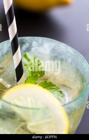 Cold Lemonade With Ice Cubes and Lemon on Dark Background Stock Photo