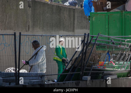 Paris, France. 9th May, 2017. City workers dump the remains of the camp into big refuse container. City officials of Paris are cleaning the abandoned tents of the refugee camp that has spread around the reception centre. The camp was evicted earlier in the morning. Photo: Cronos/Michael Debets/Alamy Live News Stock Photo