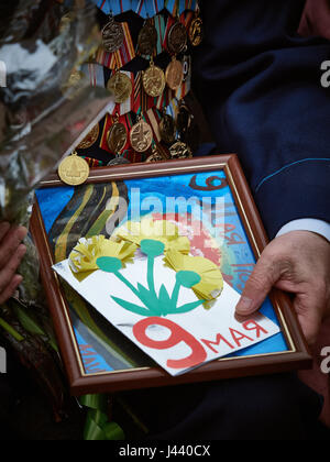 Vitebsk, Belarus. 9th May, 2017. The procession along the main street of the city. Participate in as the veterans of the great Patriotic war and young generation of Vitebsk. People give flowers to the elderly and lay wreaths at the monument 'Eternal Fire'. Credit: Alexey Vronsky/Alamy Live News Stock Photo