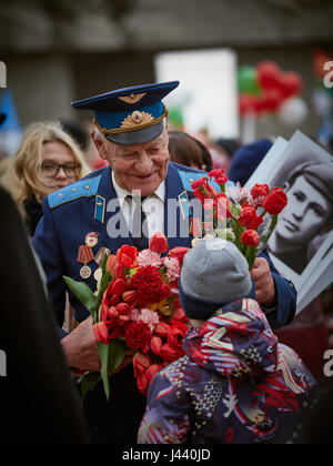 Vitebsk, Belarus. 9th May, 2017. The procession along the main street of the city. Participate in as the veterans of the great Patriotic war and young generation of Vitebsk. People give flowers to the elderly and lay wreaths at the monument 'Eternal Fire'. Credit: Alexey Vronsky/Alamy Live News Stock Photo