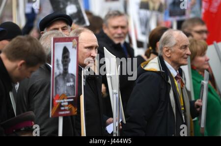 Moscow, Russia. 9th May, 2017. Russian President Vladimir Putin, holds a portrait of his war veteran father Vladimir Spiridonovich Putin, during the Immortal Regiment patriotic march marking the annual Victory Day celebrations and the 72nd anniversary of the end of World War II in Red Square May 9, 2017 in Moscow, Russia. Credit: Planetpix/Alamy Live News Stock Photo