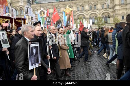 Moscow, Russia. 9th May, 2017. Russian President Vladimir Putin, holds a portrait of his war veteran father Vladimir Spiridonovich Putin, during the Immortal Regiment patriotic march marking the annual Victory Day celebrations and the 72nd anniversary of the end of World War II in Red Square May 9, 2017 in Moscow, Russia. Credit: Planetpix/Alamy Live News Stock Photo