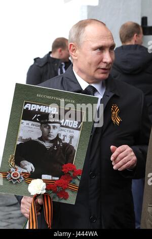 Moscow, Russia. 9th May, 2017. Russian President Vladimir Putin holds a portrait of his war veteran father Vladimir Spiridonovich Putin, during the Immortal Regiment patriotic march marking the annual Victory Day celebrations and the 72nd anniversary of the end of World War II in Red Square May 9, 2017 in Moscow, Russia. Credit: Planetpix/Alamy Live News Stock Photo