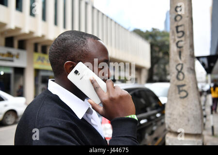 (170510) -- NAIROBI, May 10, 2017(Xinhua) -- A man uses Tecno mobile phone in downtown Nairobi, capital of Kenya, May 9, 2017. Chinese mobile phone manufacturer Tecno Mobile sales reached 25 million devices, including 9 million smartphones in 2015, helping it to sustain the most 'popular' brand status in Africa. (Xinhua/Sun Ruibo) (jmmn) Stock Photo