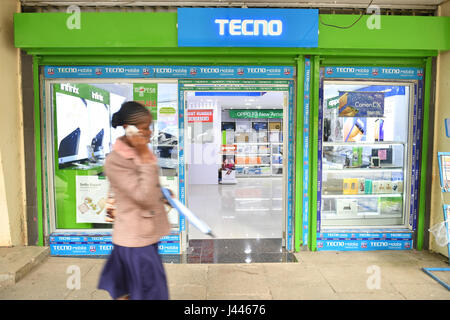 (170510) -- NAIROBI, May 10, 2017 (Xinhua) -- A pedestrian walks past a mobile phone shop in downtown  Nairobi, capital of Kenya, May 9, 2017. Chinese mobile phone manufacturer Tecno Mobile sales reached 25 million devices, including 9 million smartphones in 2015, helping it to sustain the most 'popular' brand status in Africa. (Xinhua/Sun Ruibo) (jmmn) Stock Photo
