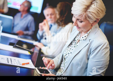 Female coworker using cell phone Stock Photo