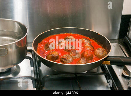 Cooking Meatballs In A Frying Pan with a Tomato Sauce Stock Photo