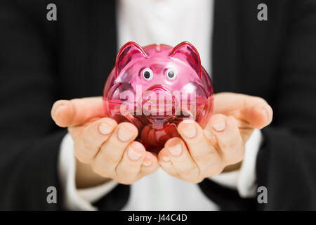 business profit savings concept - woman holding piggy bank in hands Stock Photo