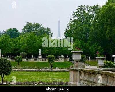 Eiffel Tower seen in almost silhouette through the clouds. Rainy day in the Luxembourg Gardens. Paris, France Stock Photo