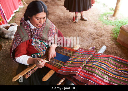 Cusco, Peru -April 21, 2017: Peruvian woman making traditional wool. Woman produce alpaca cloth Stock Photo
