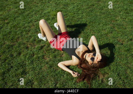 A young woman lying down on grass Stock Photo