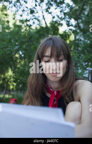 A young woman behind a piece of paper Stock Photo