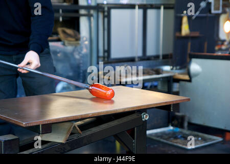 SEATTLE, WASHINGTON, USA - JAN 23rd, 2017: A man takes motlen glass and shapes it using some specialized tools for glassblowing art at an exhibit by American artist Dale Chihuly at Chihuly Garden and Glass Museum Stock Photo