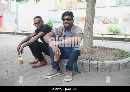 Two young men sitting and smiling. Stock Photo