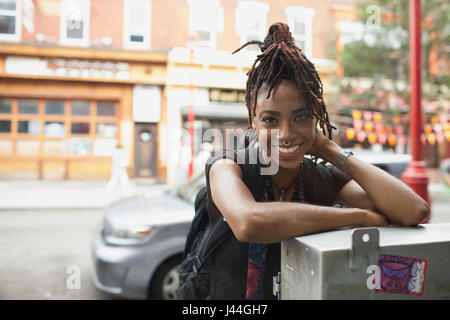 A young woman leaning against a metal box. Stock Photo