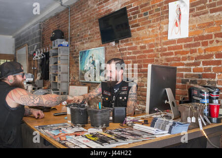 Two young men shaking hands over a desk. Stock Photo