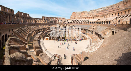2 picture stitch panoramic interior view of the amphitheatre inside the Colosseum with tourists visitors on a sunny day taken from the middle level 2. Stock Photo