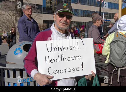 Asheville, North Carolina, USA - February 25, 2017: A man holds a sign saying 'Universal Healthcare Coverage' at an Obamacare (Affordable Care Act) ra Stock Photo