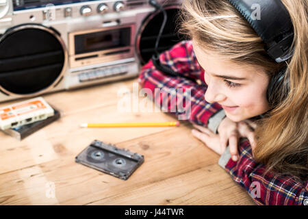 Retro styled music header with young girl listening to music on boombox with headset Stock Photo