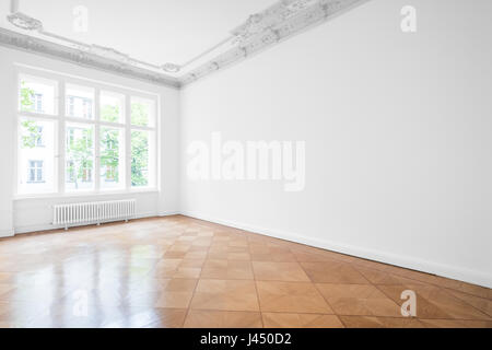 Empty room with parquet floor , white walls and stucco ceiling - new renovated flat in old building Stock Photo