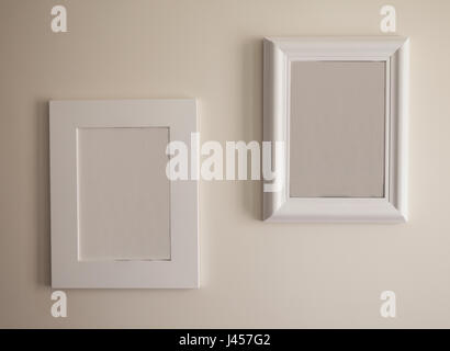 Closeup view on two empty picture frames on white wall. Stock Photo