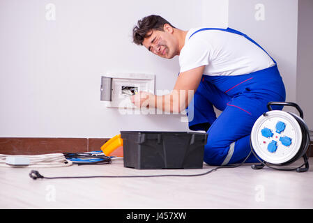 Funny Man doing electrical repairs at home Stock Photo