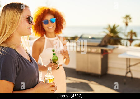 Two beautiful woman holding drinks with smiles on their faces Stock Photo