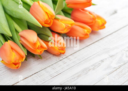 Red tulips over shabby white wooden background Stock Photo