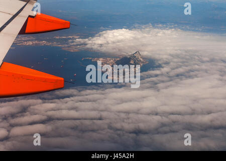 An aerial view of the rock of Gibraltar poking out from low flying clouds as seen from an Easy Jet aeroplane window seat on its way to Tangiers. Stock Photo