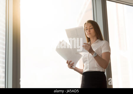 Businesswoman reading document with statistic data Stock Photo