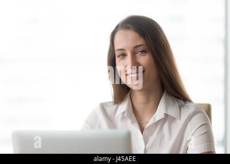 Happy businesswoman working on laptop in office Stock Photo