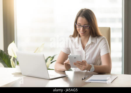 Female entrepreneur working with apps on tablet Stock Photo