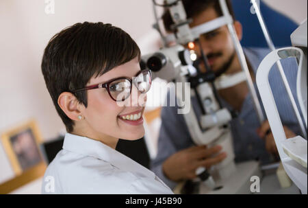 Optometrist examining patient in ophthalmology clinic with professional equipment Stock Photo