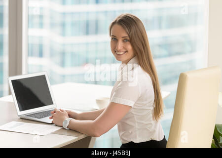 Happy young female entrepreneur working at office Stock Photo