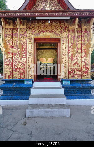 East facade and entry-1957 AD.restored-glass mosaic inlaid in red stucco showing religious and daily life-16th.ctry.bronze reclining Buddha inside. Re Stock Photo